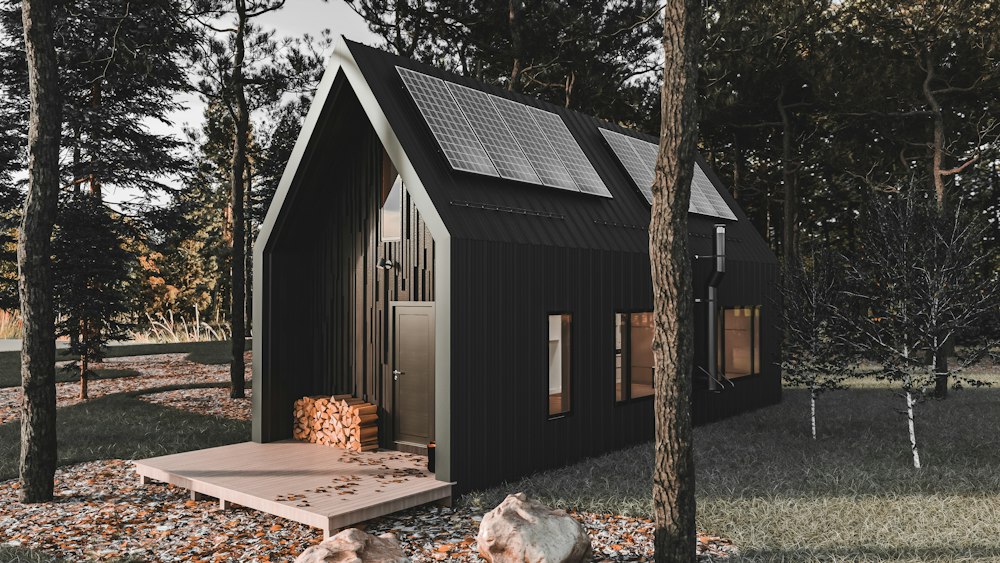 Casa prefabricada moderna negra de un piso entre árboles