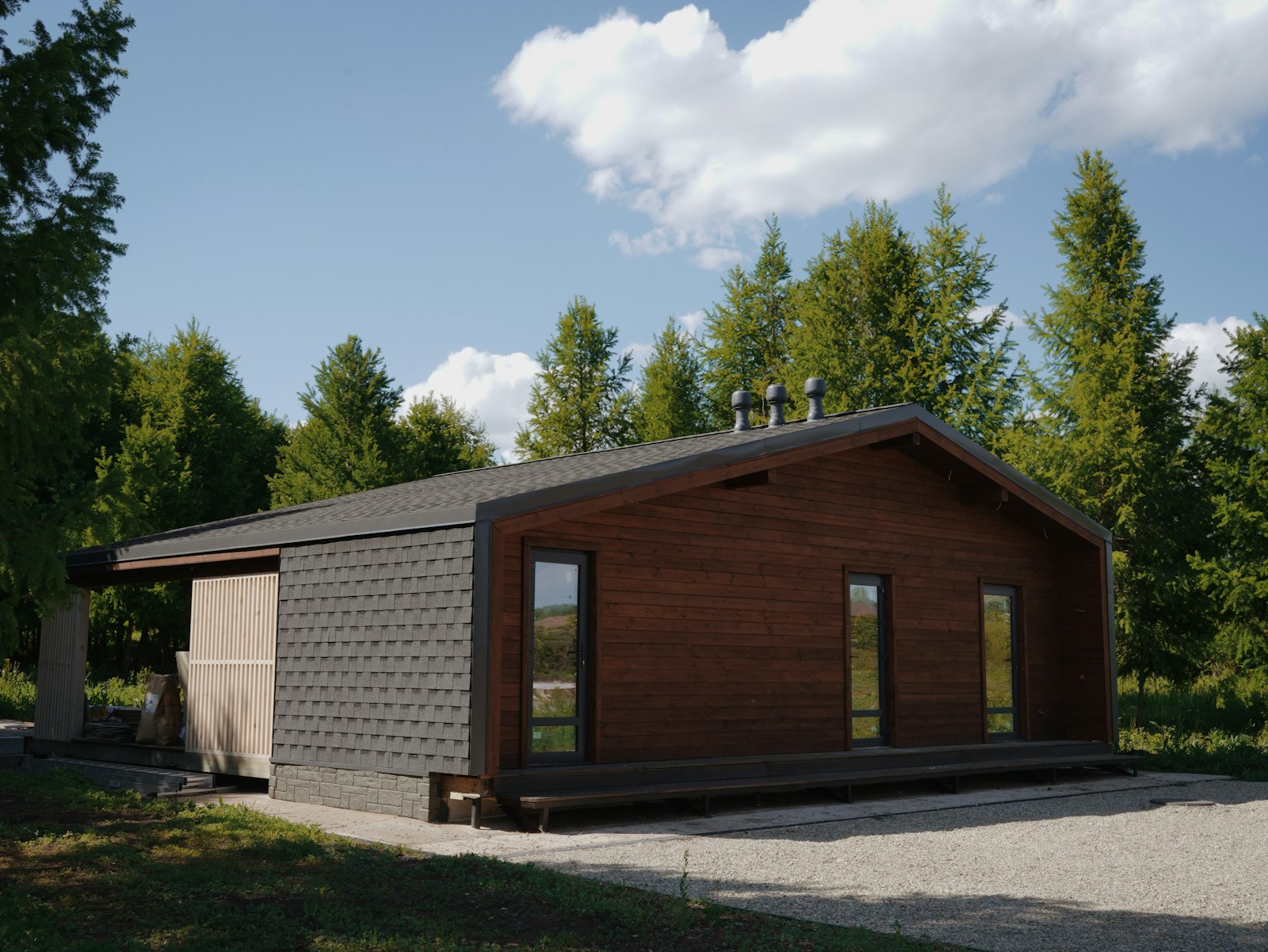 Casa prefabricada económica de madera sobre un terreno con grava