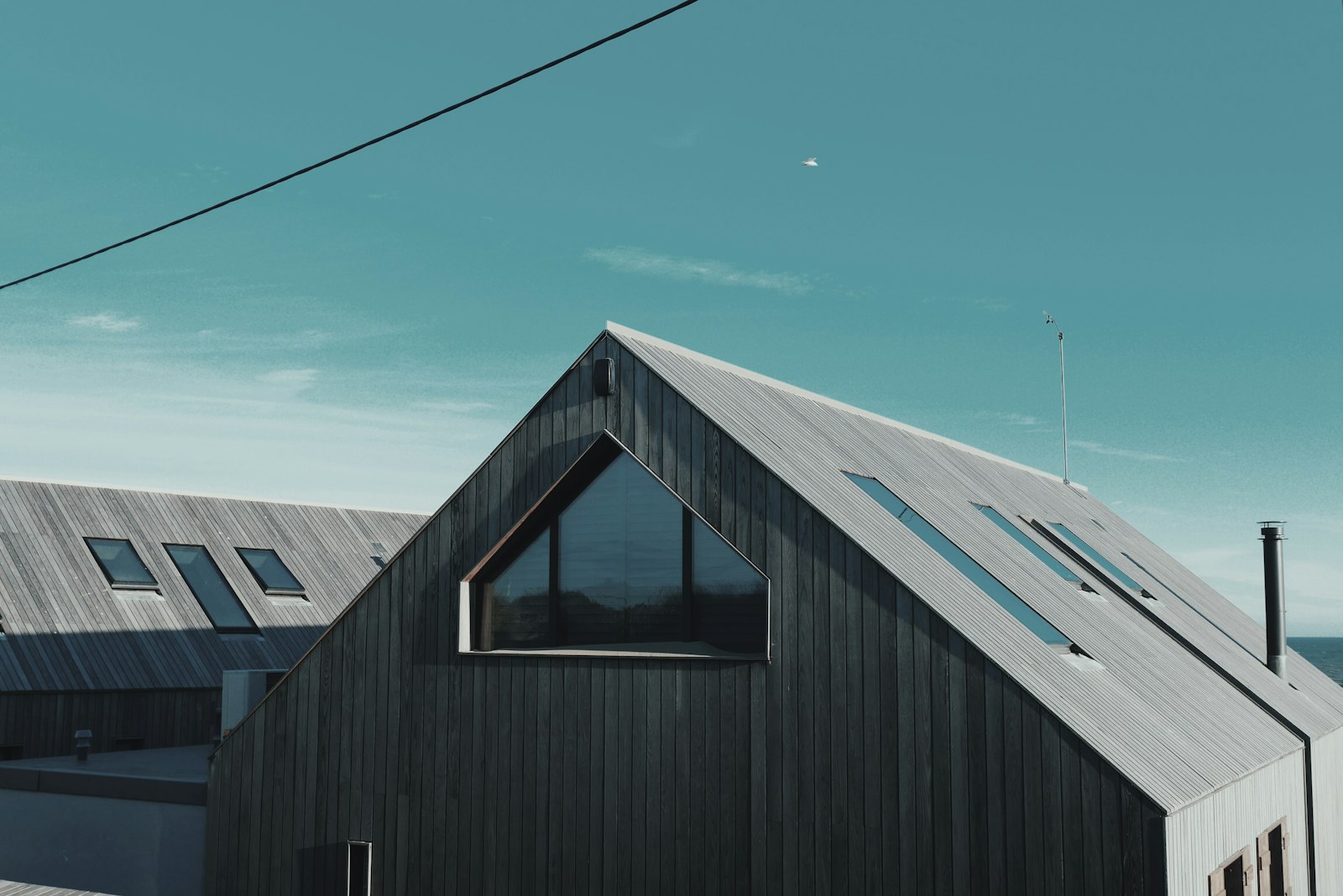 Casa prefabricada gris de madera junto al agua